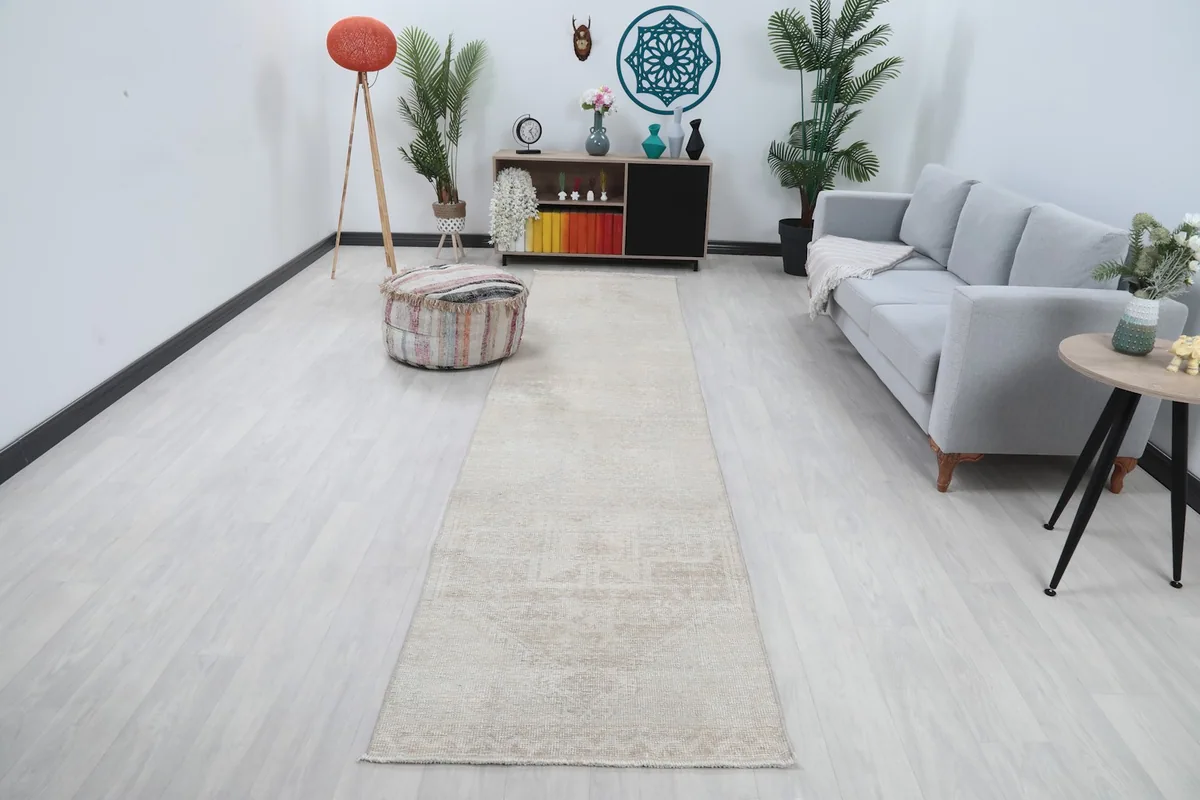 Long view of the beige runner rug in a modern living space with light walls and furniture