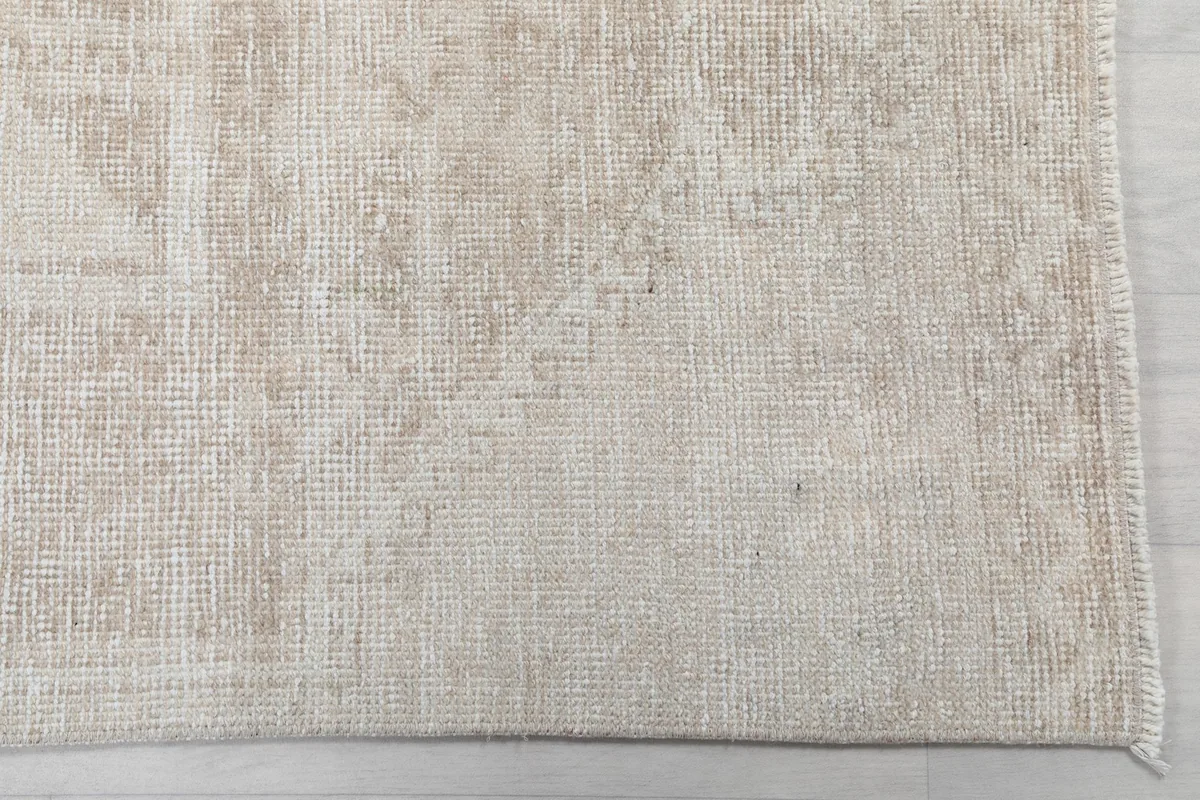 Close-up of the subtle geometric patterns and texture of the beige vintage runner
