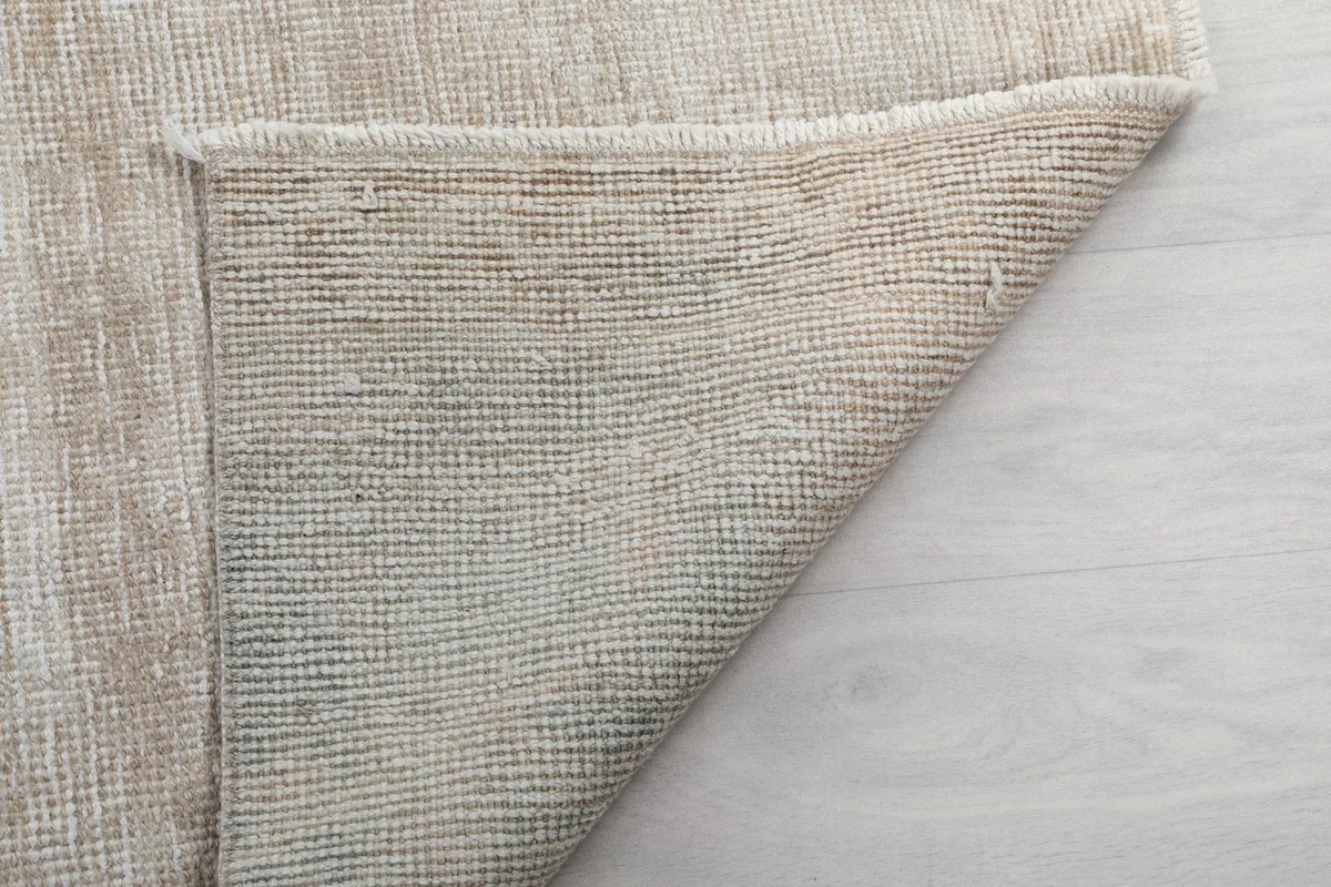 Close-up of the back of the rug, showing the tightly woven cotton foundation