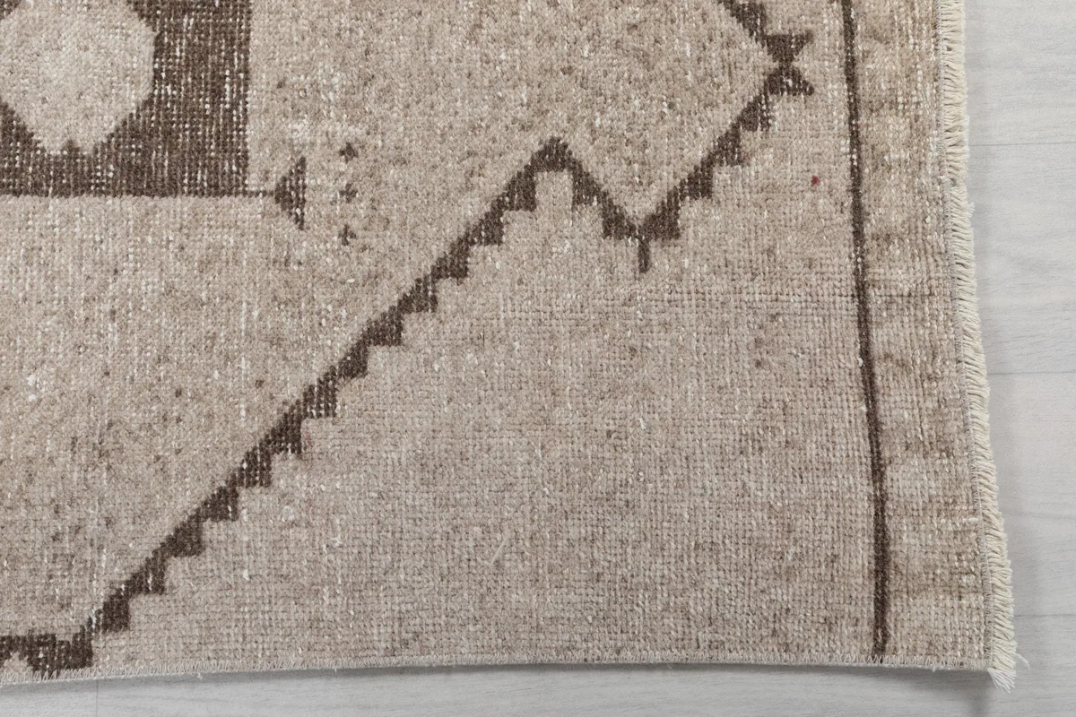 Detailed view of the corner and border of the runner rug, showing the geometric patterns and fringe.