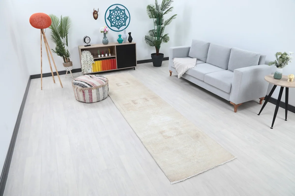 Angled view of the beige runner rug in a living space, showing its length