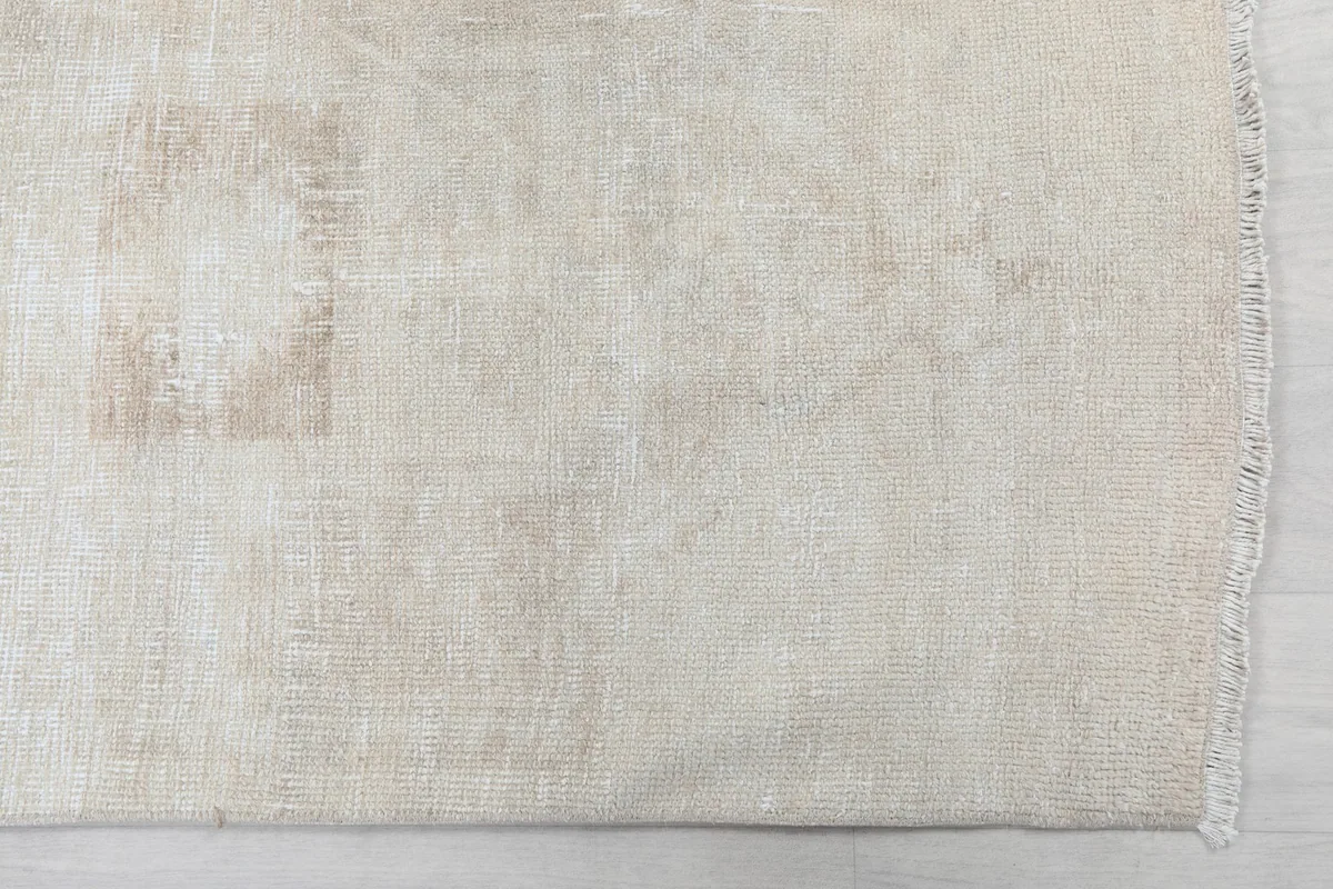 Detailed view of the rug's end, showing subtle geometric patterns and fringe