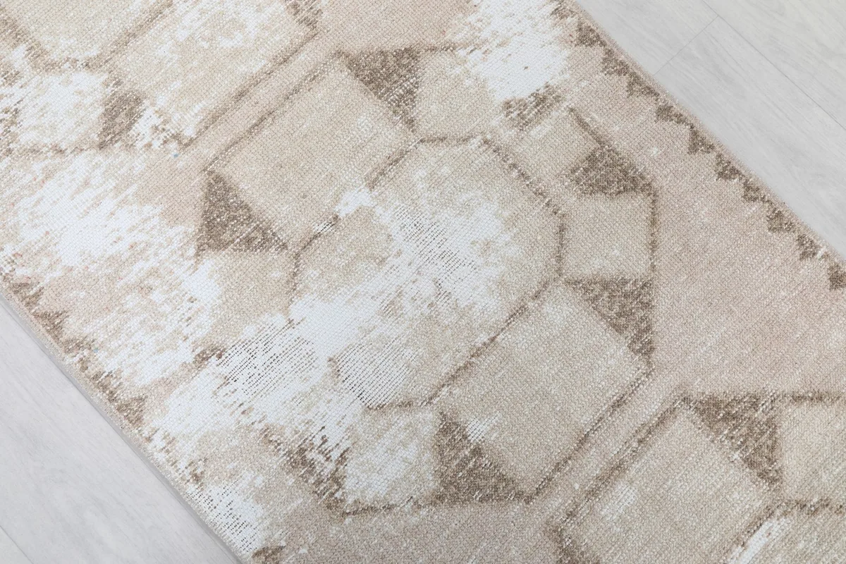 Angled view highlighting the distressed areas and geometric design of the vintage runner