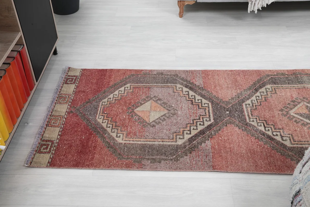 Angled view of the runner rug showing its length and the repetitive geometric medallion design.