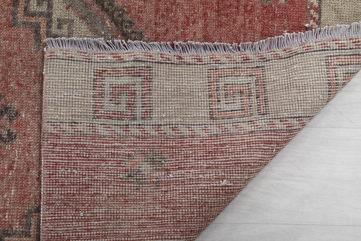 Close-up of the rug's underside and fringe, showing the tight hand-knotting and material.