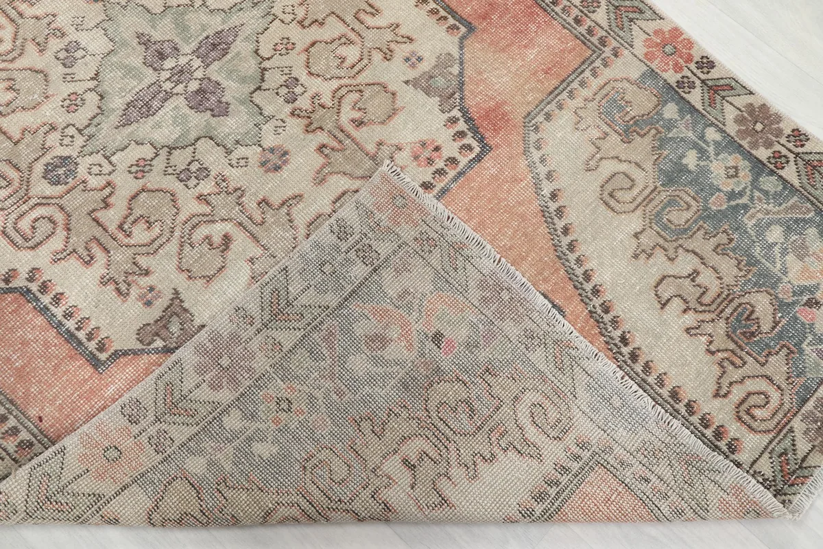 Folded corner of the rug revealing the wool pile and cotton foundation.