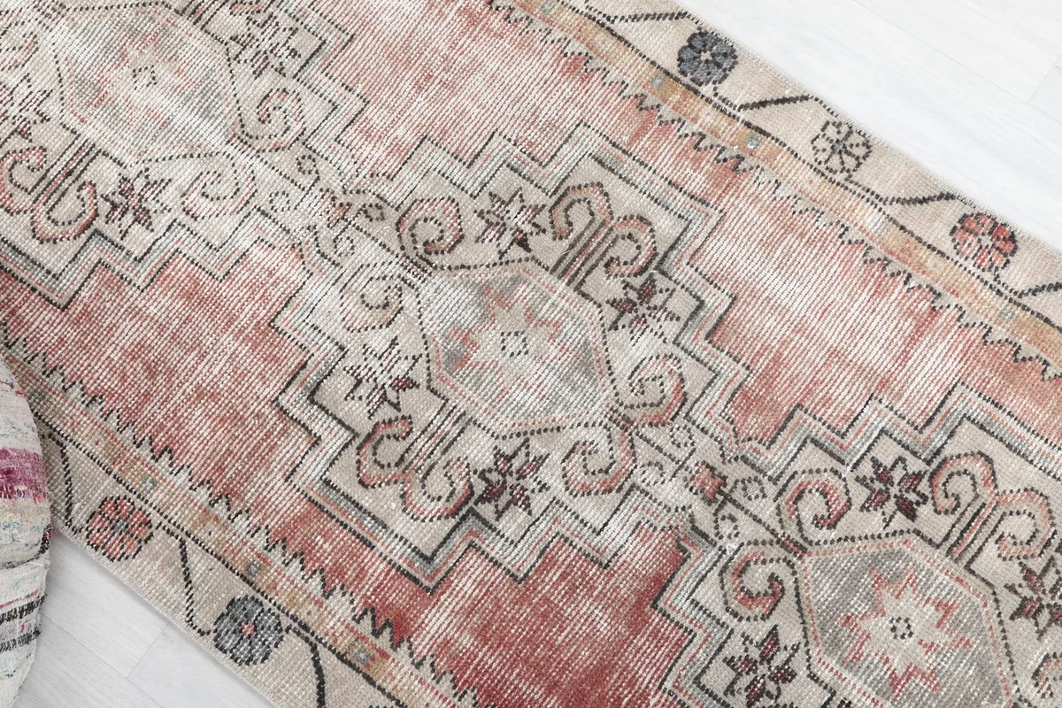 Angled close-up of the runner, focusing on the distressed rust and gray tones and tribal motifs.