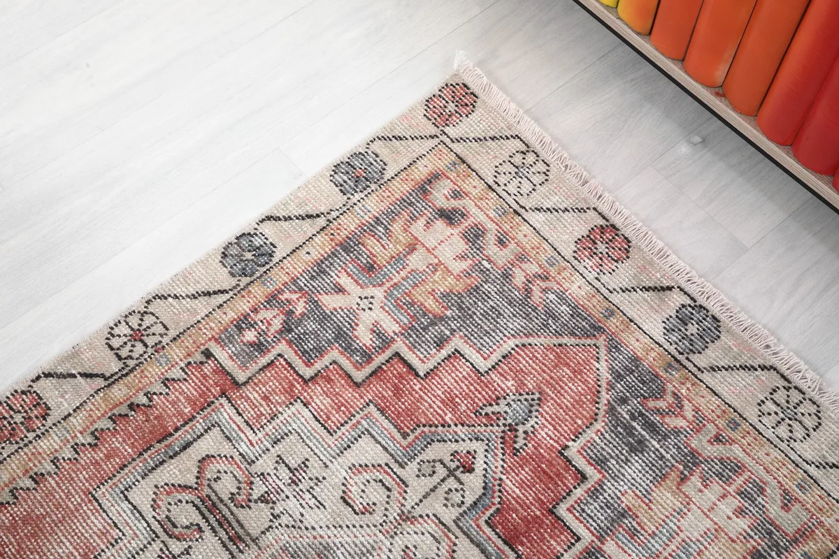 Corner detail of the rug, showing the contrasting beige border and the subtle color variations in the field.