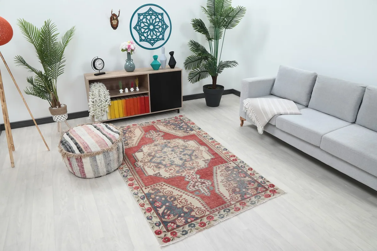 Red and ivory Anatolian rug in a room, showing its scale relative to furniture