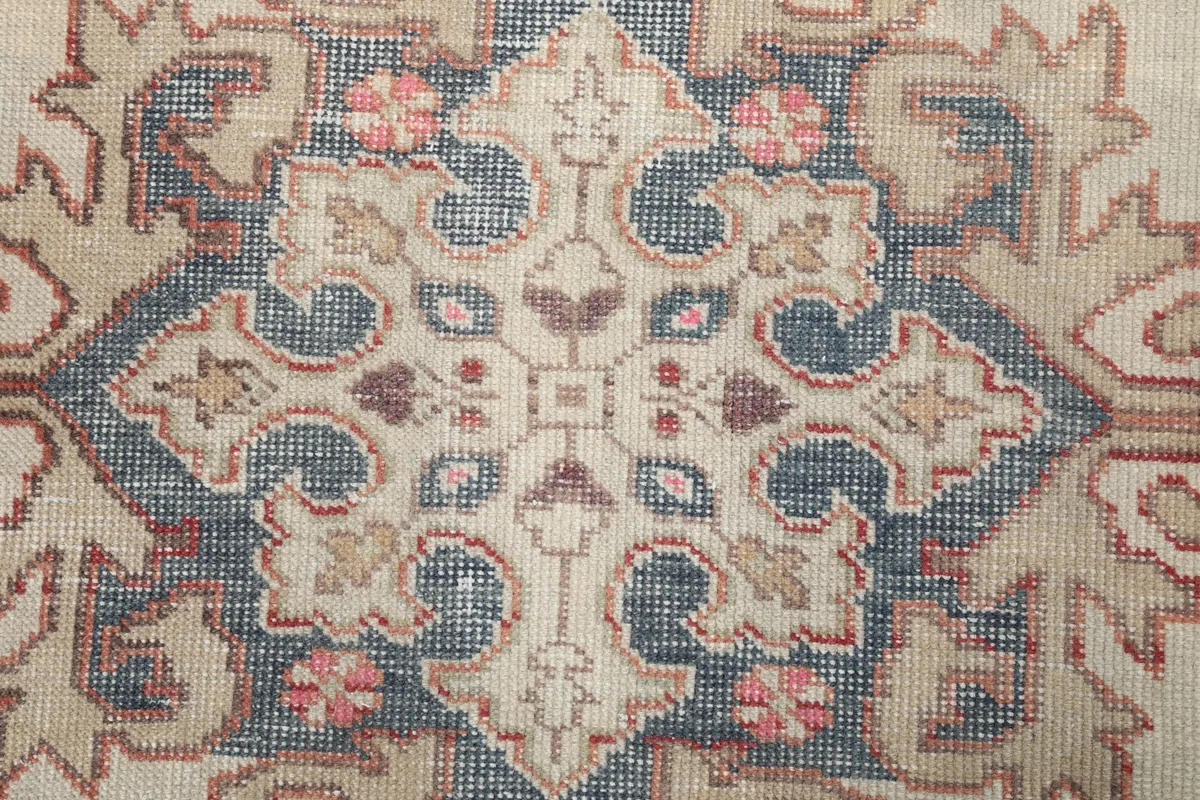 Close-up of the intricate blue and tan geometric design within the ivory medallion