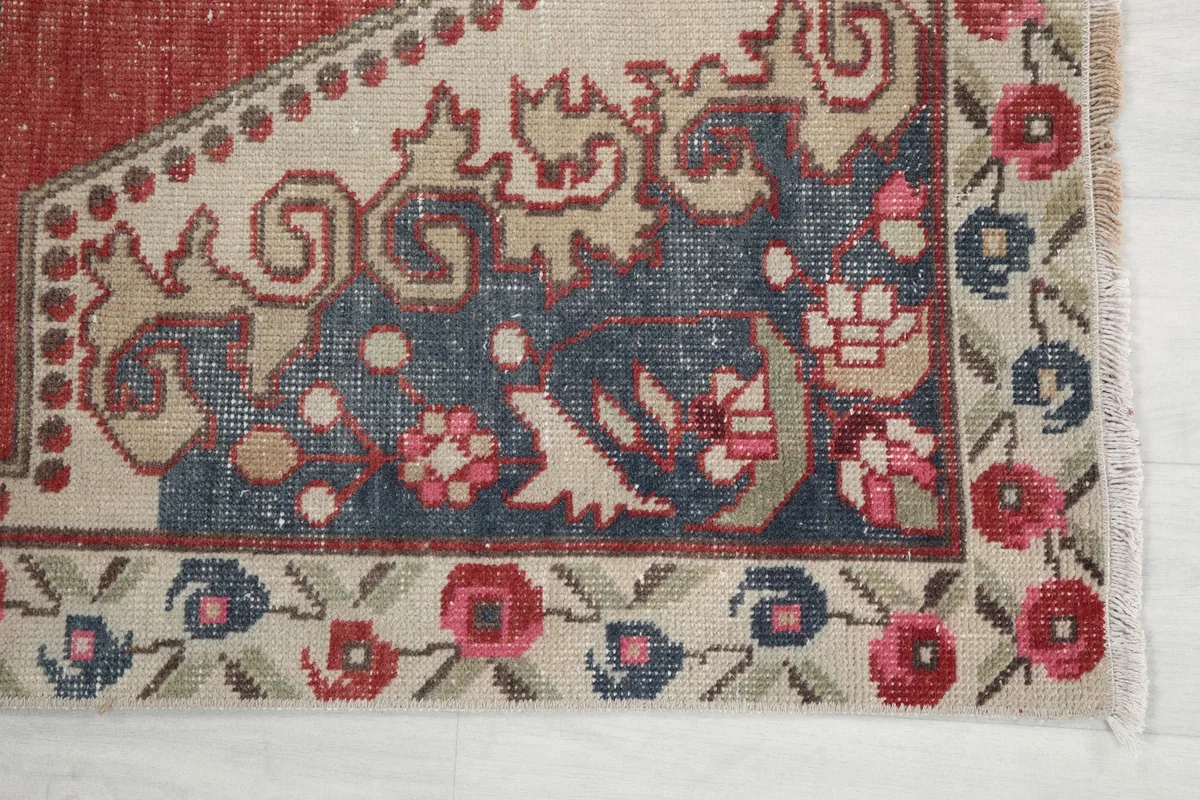 Detail of the outer border with rose and blue floral motifs on an ivory background