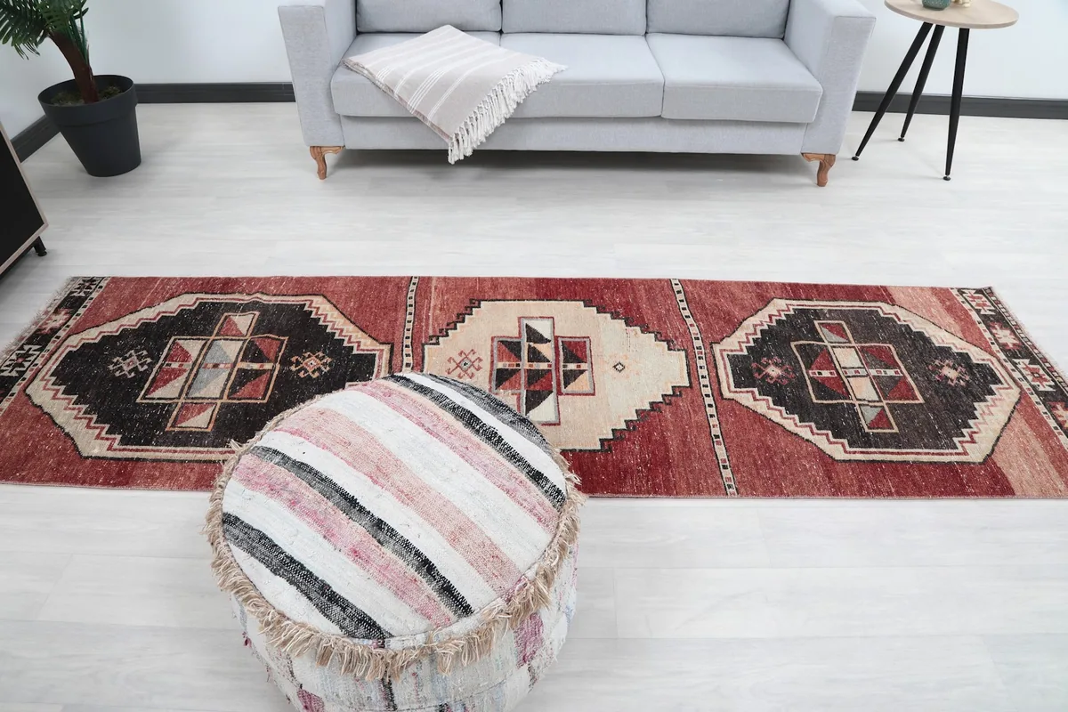 Full view of the runner rug laid out in a modern living space with a sofa and ottoman