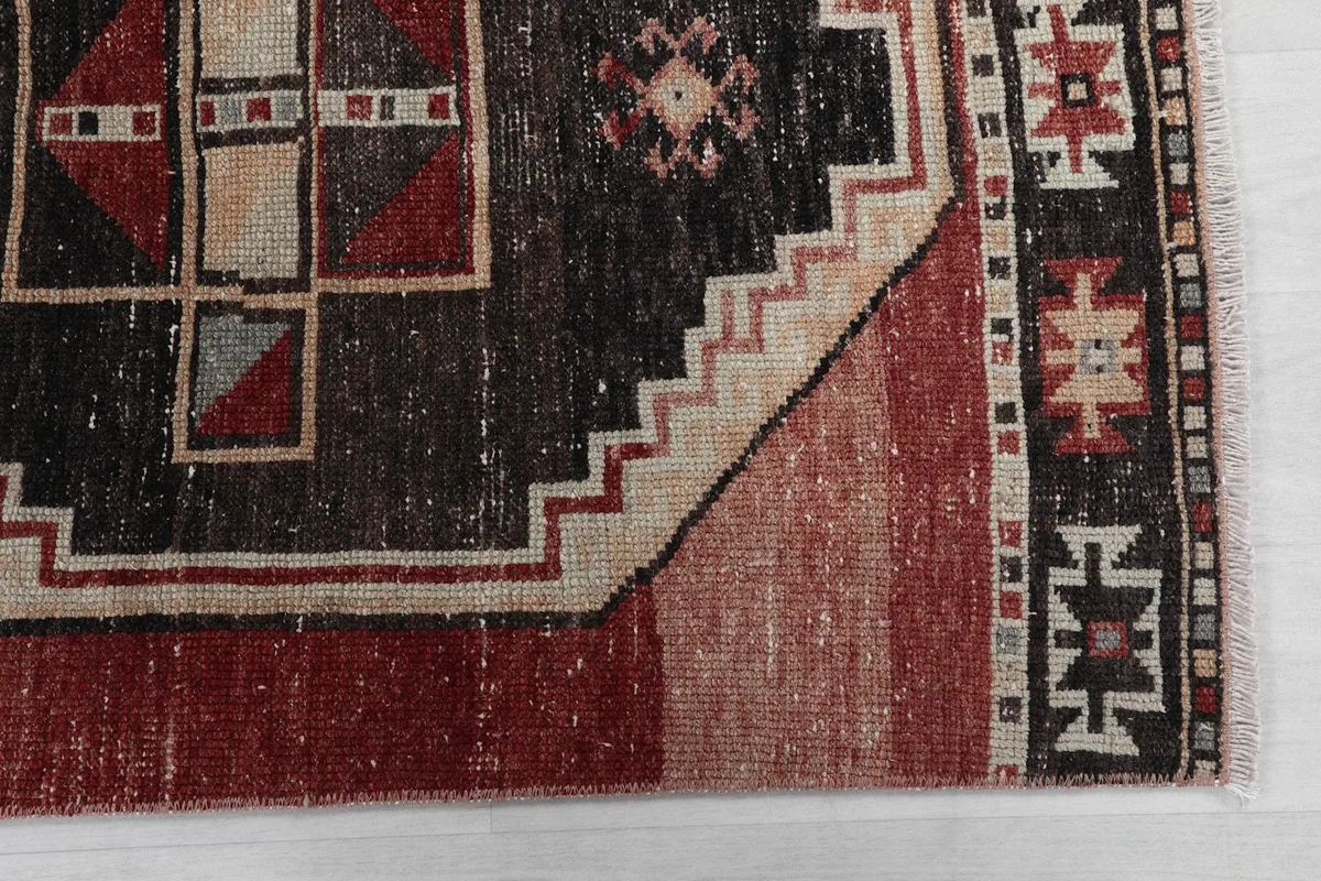 Detailed view of the black geometric medallion and border design with color variations