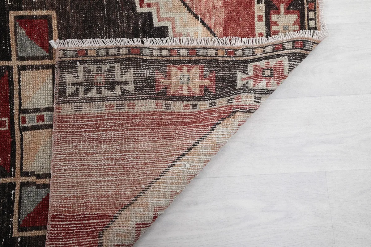 View of the back of the rug, showing the hand-knotted construction and fringe