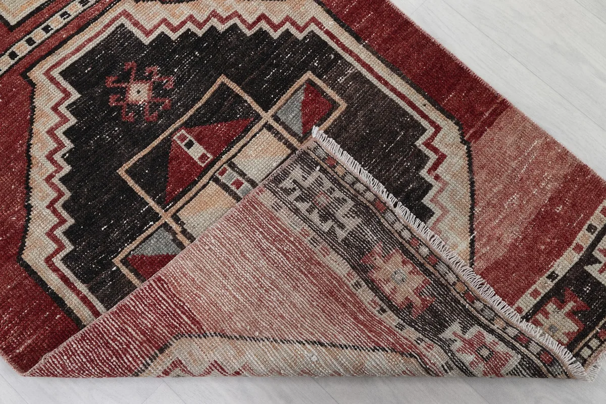 Folded corner of the rug, revealing the wool pile and cotton foundation construction