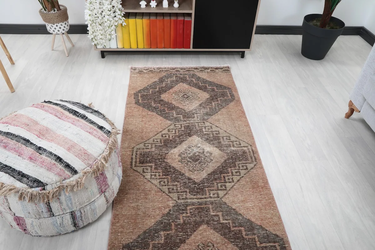 Overhead view of the tan runner rug in a room, focusing on the patterns and the surrounding decor.