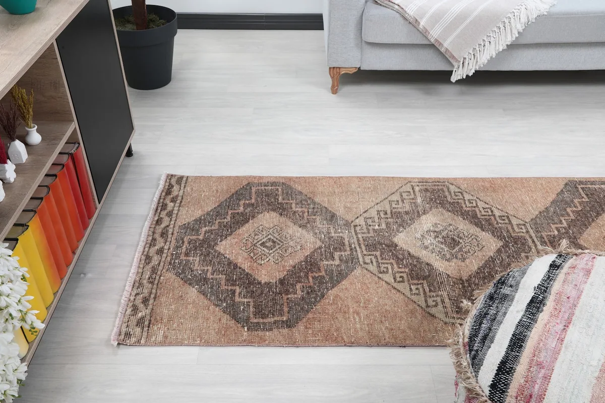 Angle view of the runner rug in a room, showing its placement relative to a console table and ottoman.
