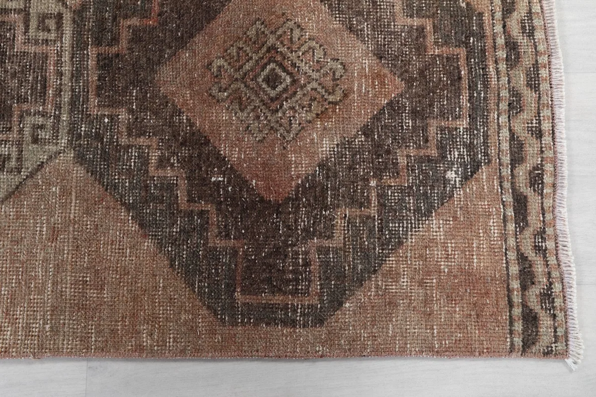 Detailed view of the tan and brown geometric patterns on the runner rug, highlighting the texture and color variation.