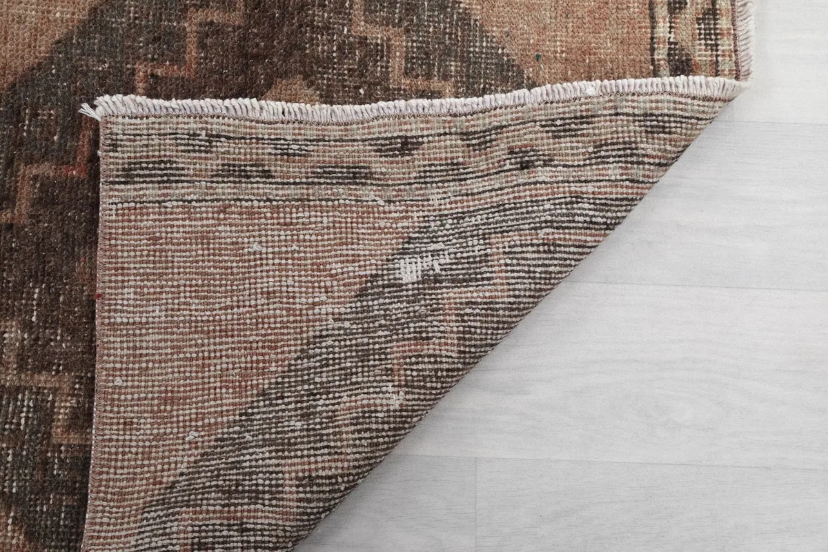 Another view of the back of the hand-knotted runner rug, revealing the intricate weaving of the cotton foundation.