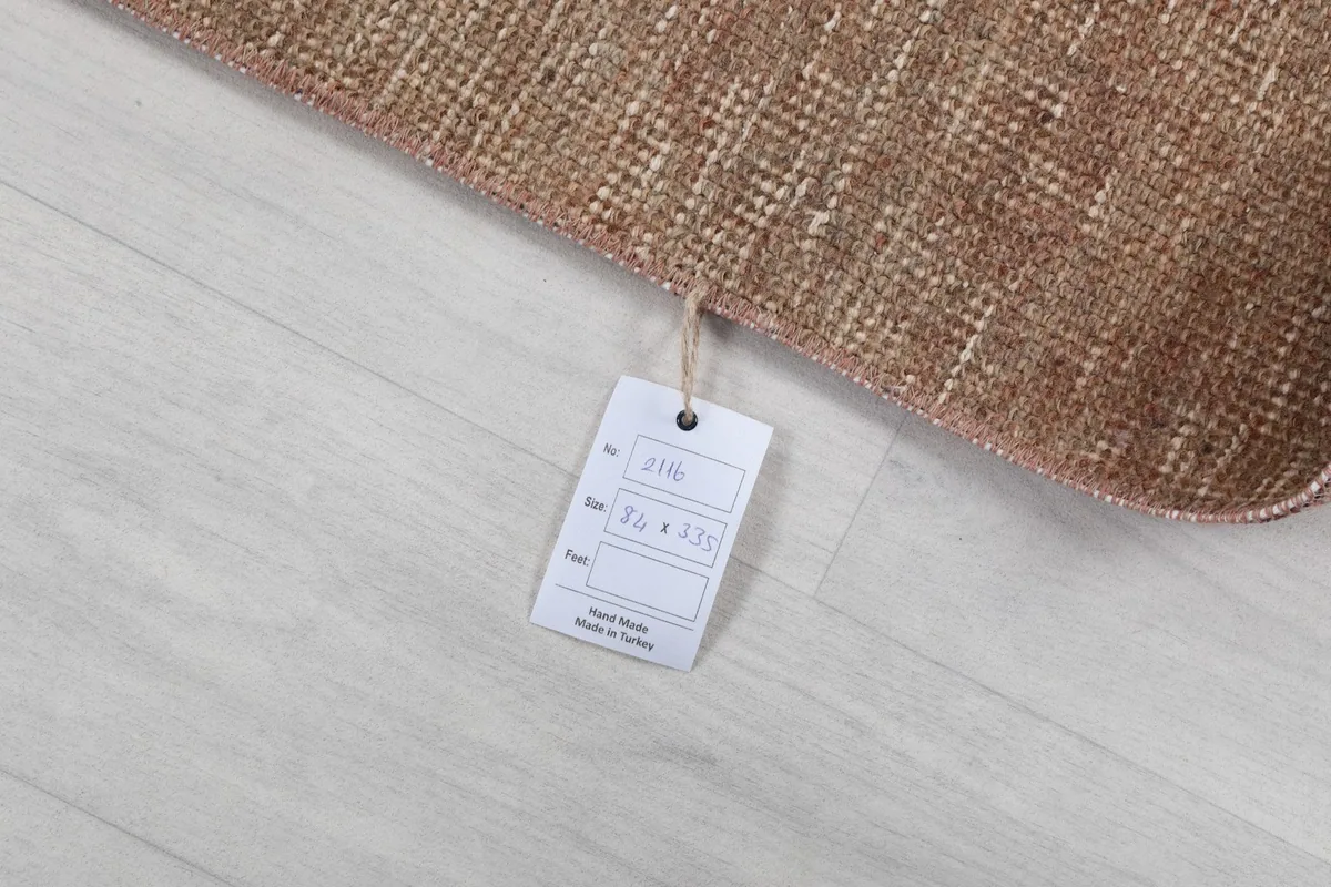 Close-up of the rug's tag, showing size and origin details, placed on the back of the runner.