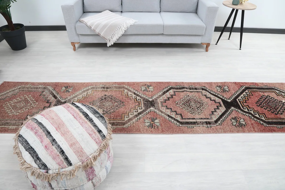 View of the full length of the runner rug in a living area, positioned between a sofa and an ottoman.