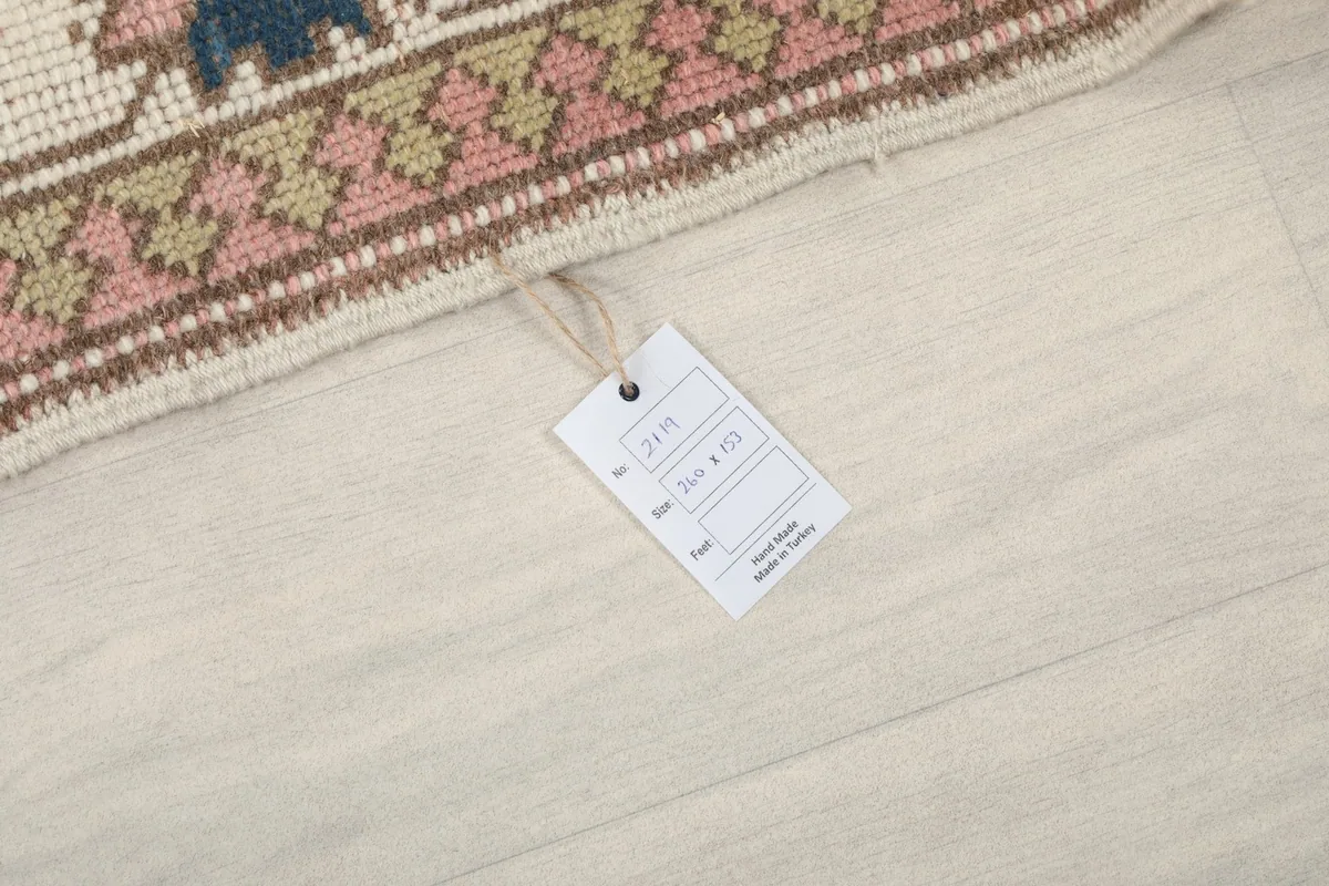 Tag attached to the rug's corner, displaying product information including size and origin.