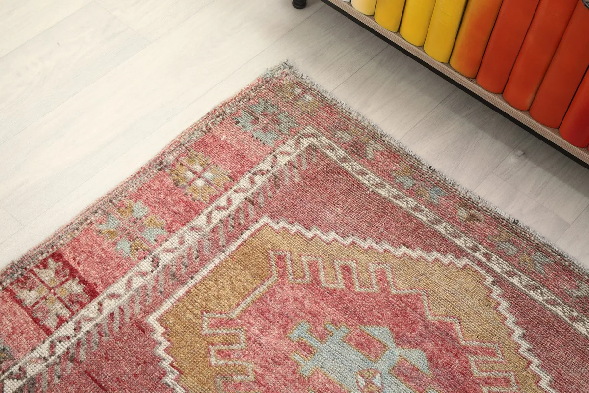 Corner detail of the rug, showing the intricate border design and slight wear