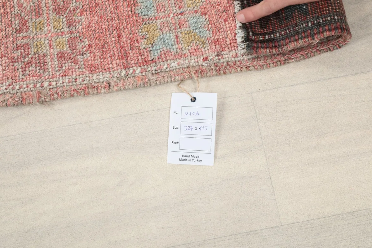 Hand holding a rolled section of the rug, next to a product tag displaying size information