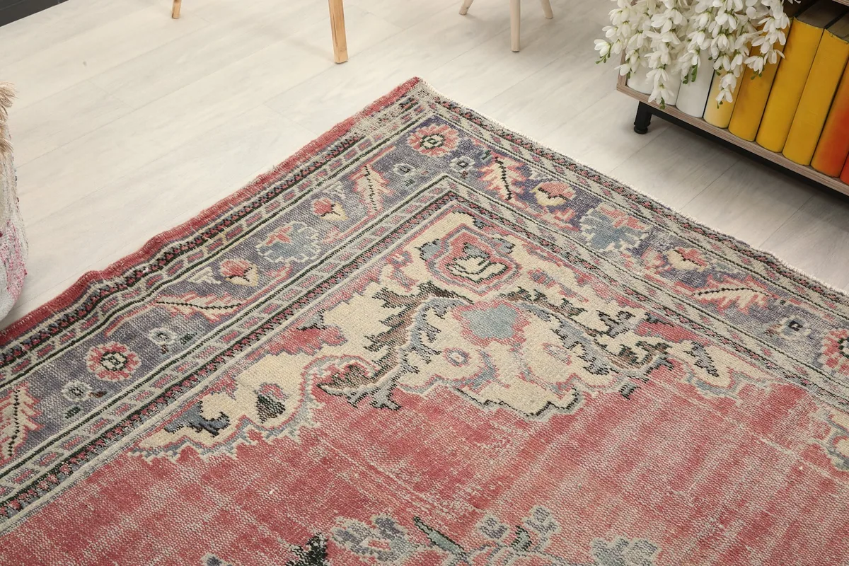 Corner angle view of the vintage rug, showing the intricate border and field patterns