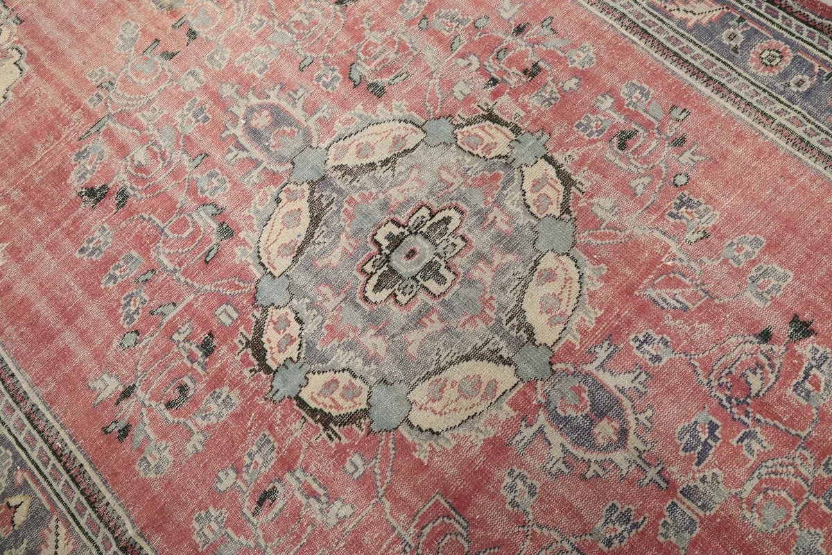 Close-up of the central medallion design in blue, gray, and beige on the rose field