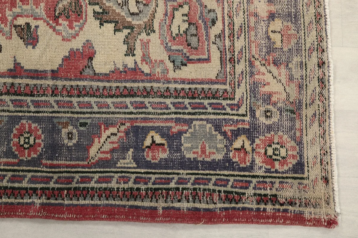 Detail of the blue and beige border pattern and outer rose edge of the vintage rug