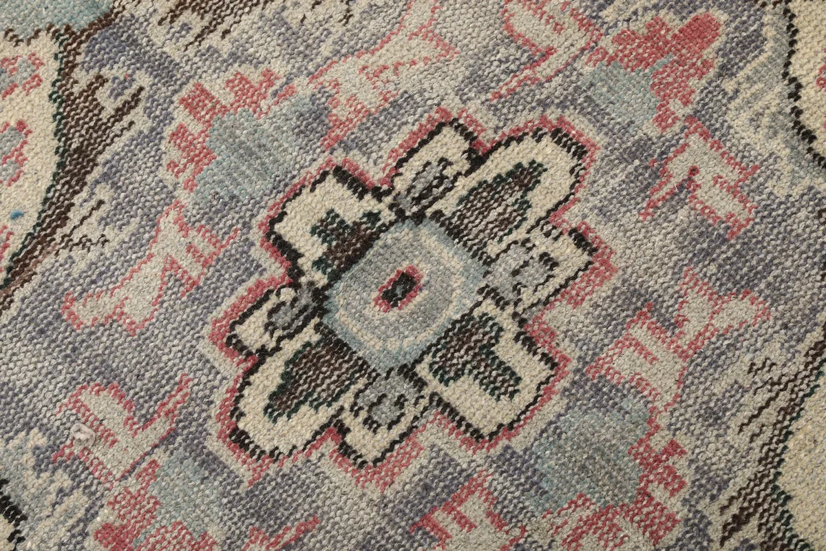 Extreme close-up showing the hand-knotted wool pile and texture of the rug