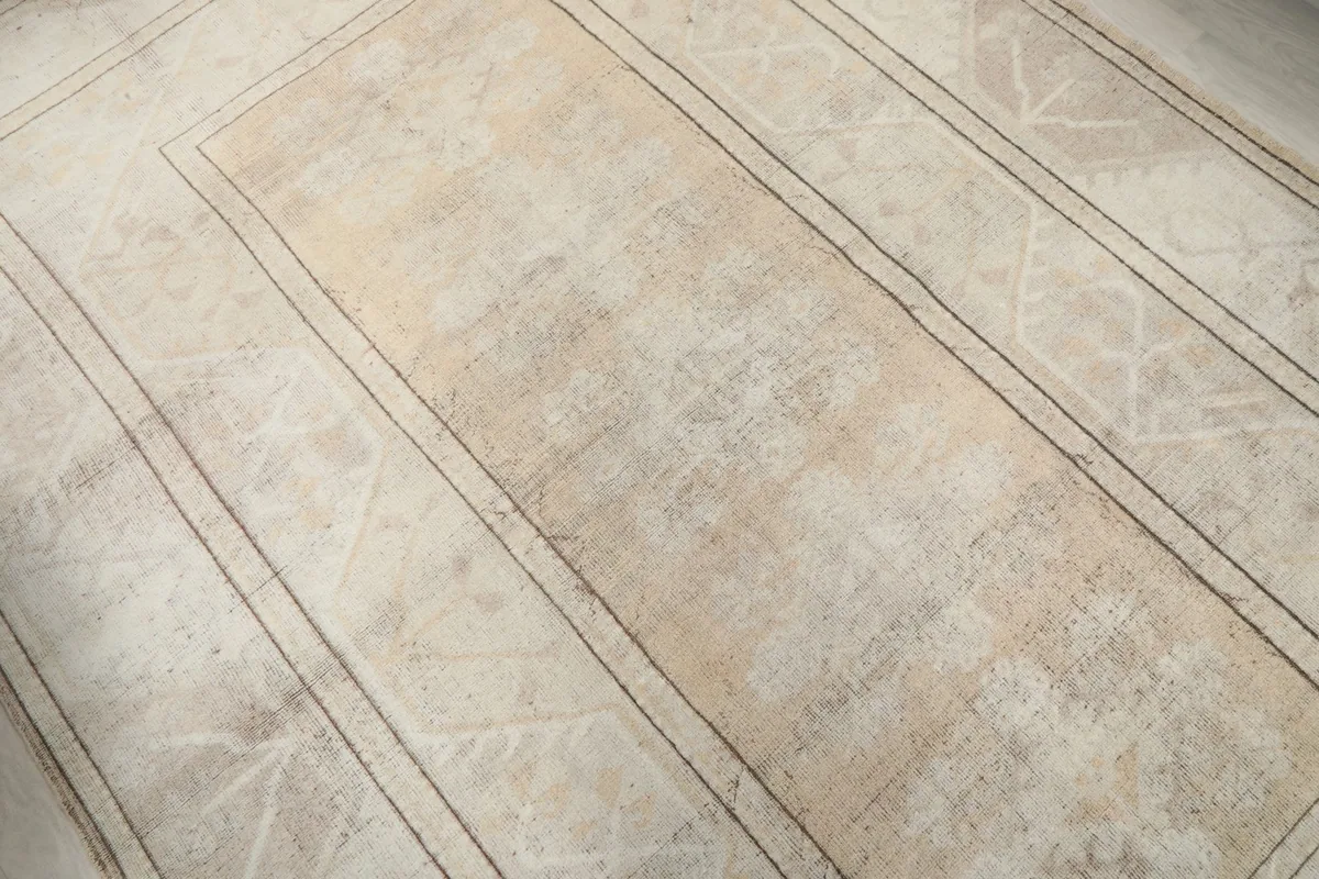 Diagonal view showing the central field and inner geometric borders of the rug