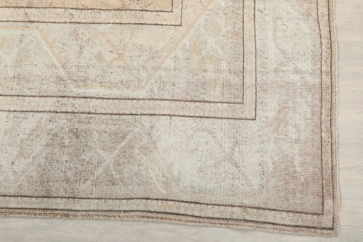 Corner detail of the geometric border and faded motifs on the vintage rug