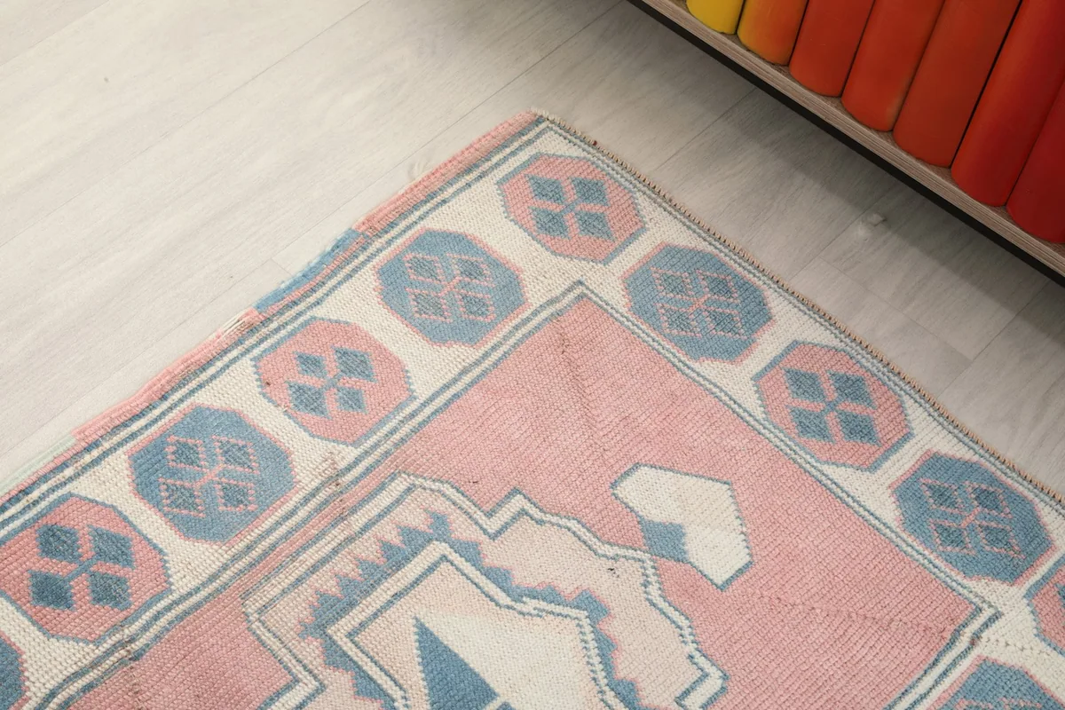 Close-up of the border design with blue octagonal motifs against a cream background