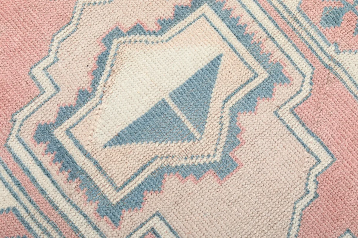 Detailed view of the low wool pile and the intricate hand-knotted geometric design