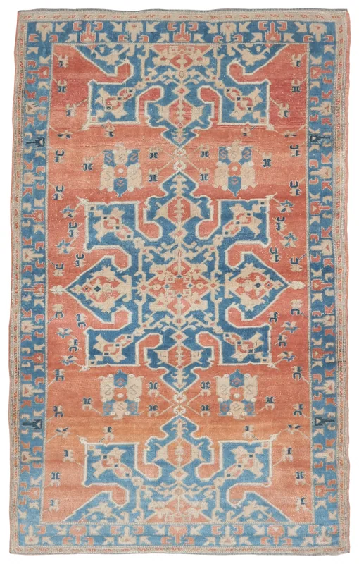 Full top view of the vintage rust and blue Anatolian area rug on a white background.
