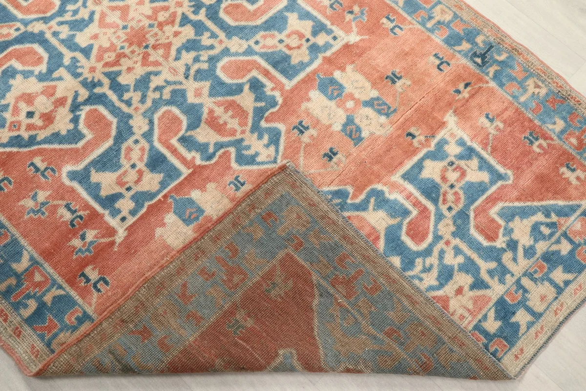 Folded corner of the rug revealing the cotton foundation and reverse side.
