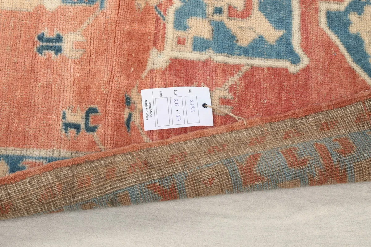 Corner of the rug with a size tag, showing the wool pile and cotton foundation.