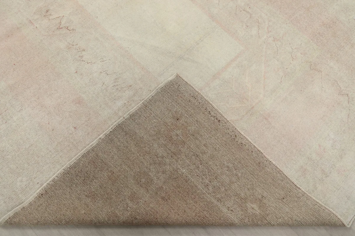 Folded corner of the rug revealing the wool pile on a cotton foundation