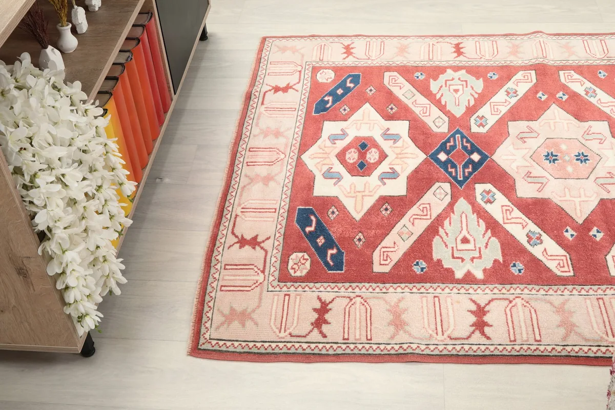 Angled top view of the rug showcasing its full pattern and colors, with a cabinet in the background.