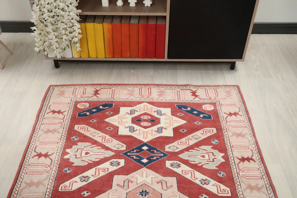 View of the rug from above, showing its placement in a room with a cabinet filled with colorful books.