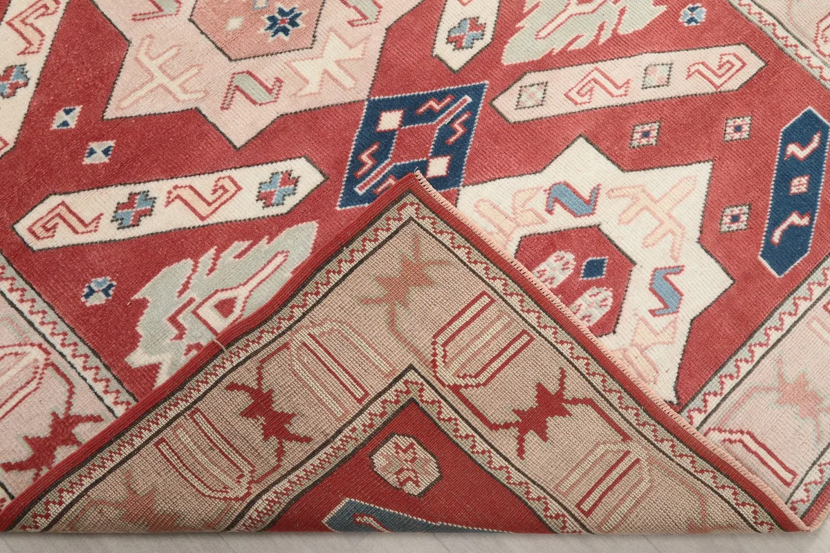 Folded corner of the rug revealing the wool pile texture and cotton foundation.
