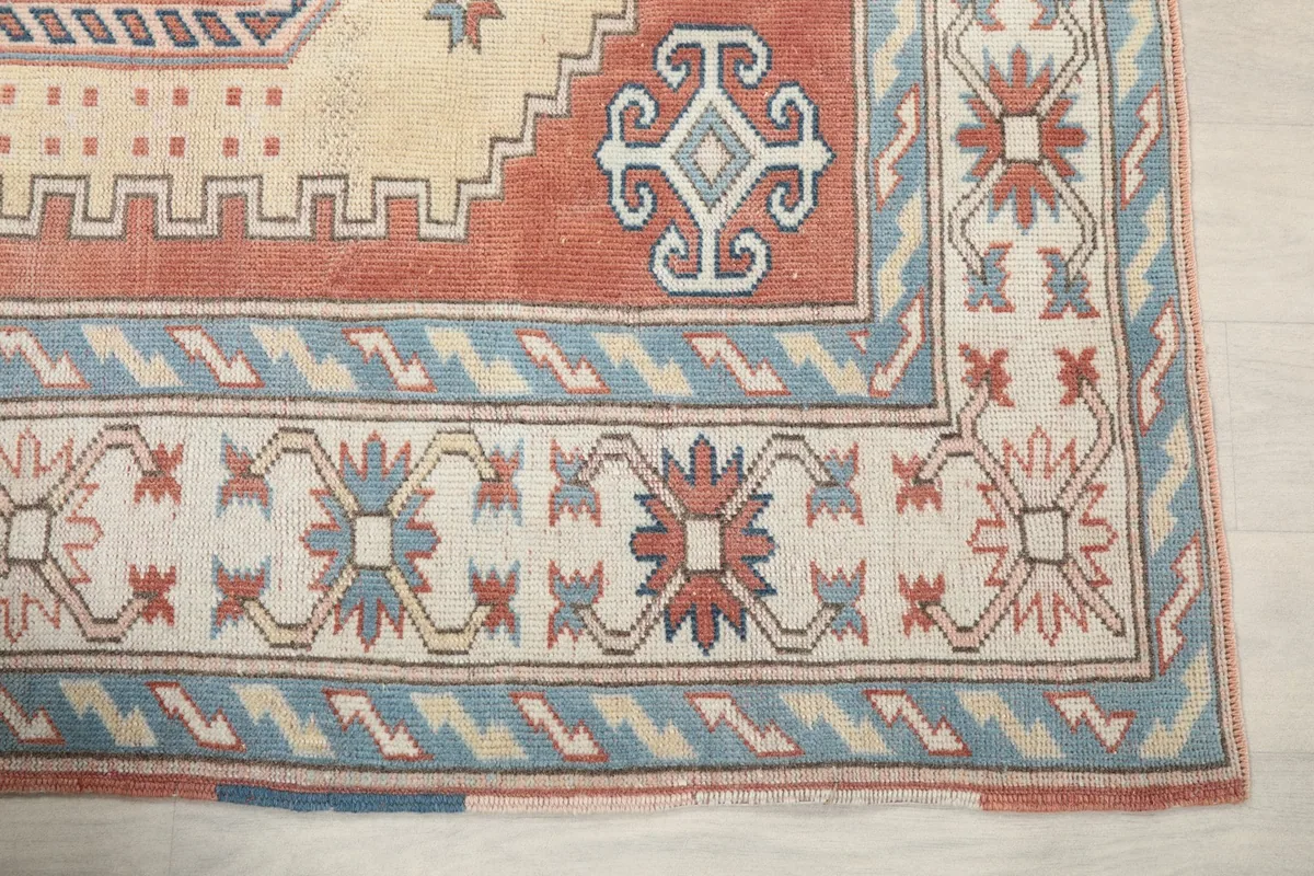 Detail of the rug's outer border with blue and rust geometric motifs