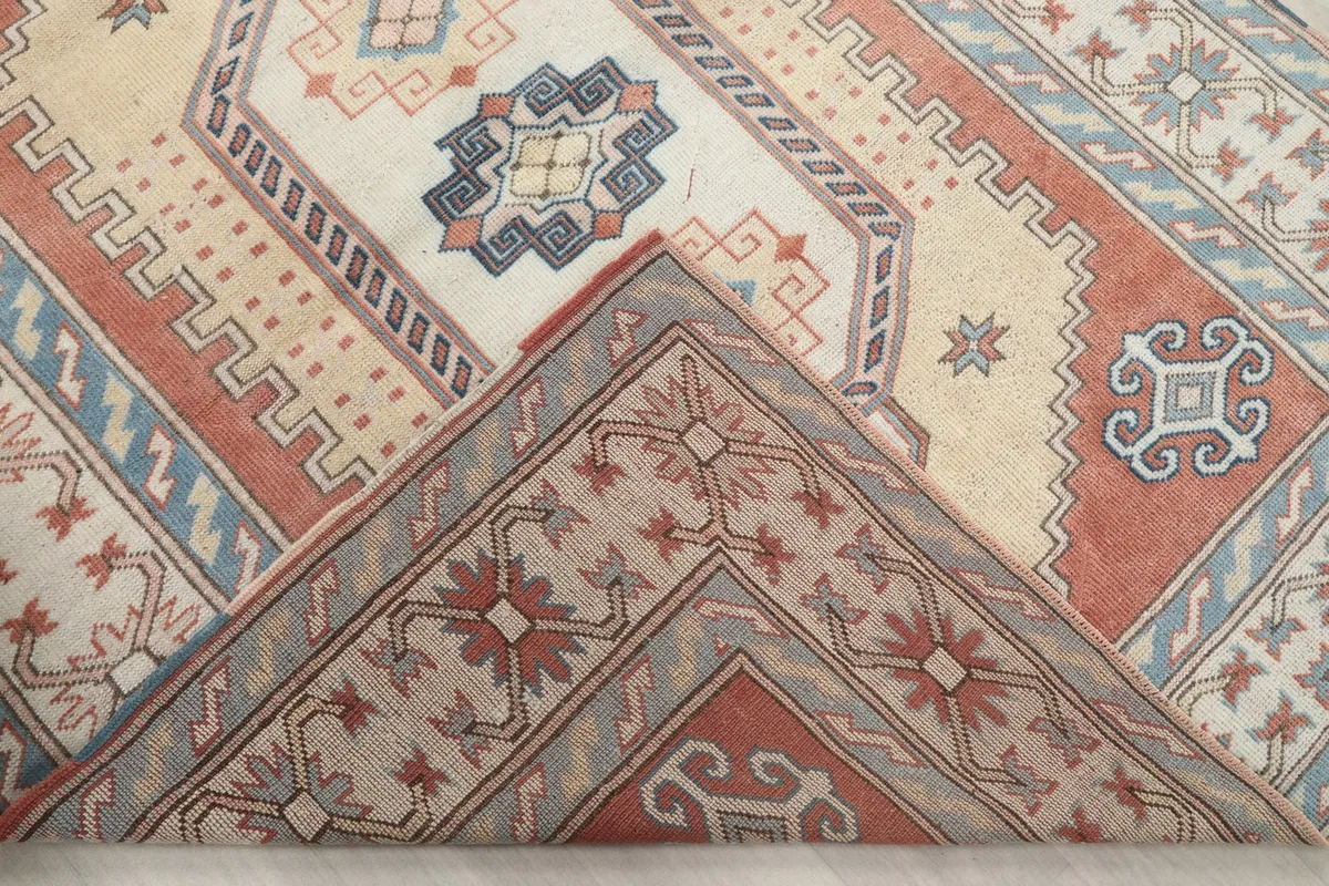 Corner of the rug folded back to show the hand-knotted wool pile and cotton foundation