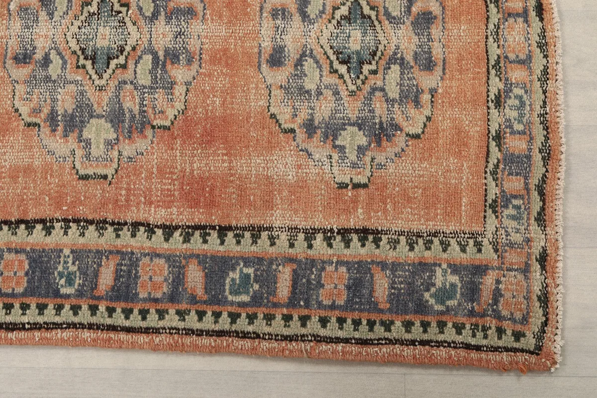 Close-up of the rug's border design with blue, orange, and black geometric patterns