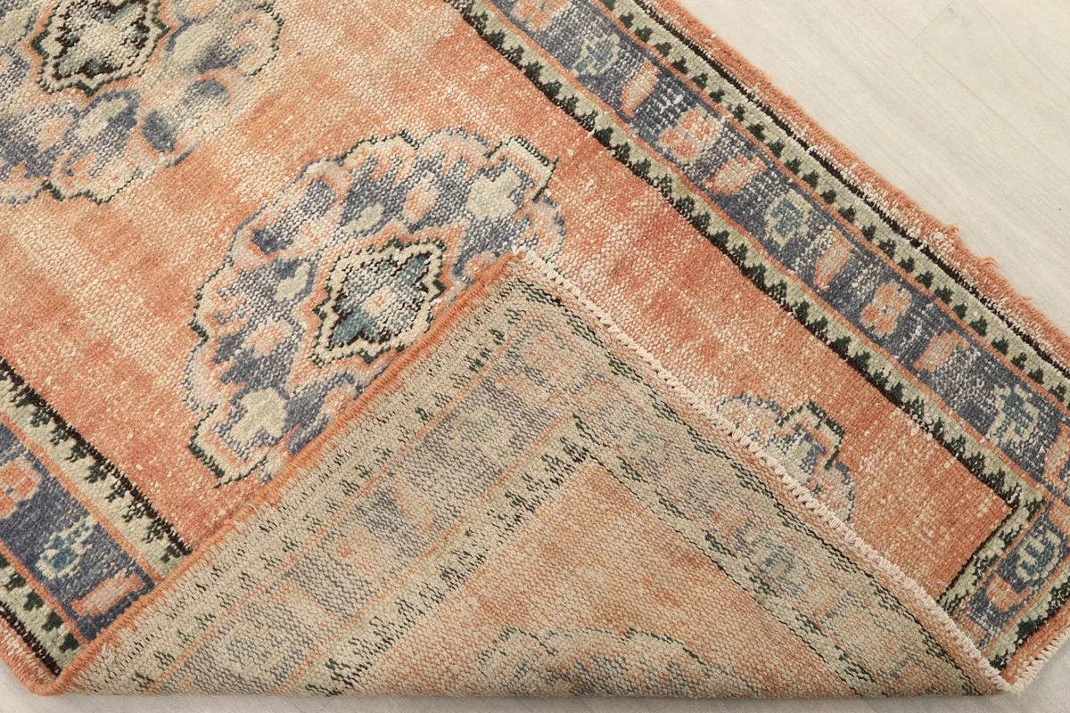 View of the rug's reverse side, revealing the hand-knotted construction and cotton foundation