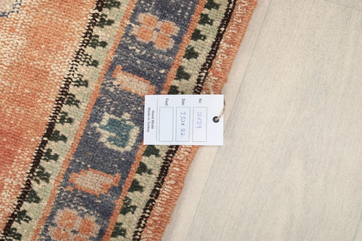 Close-up of the rug's border with a product tag, showing the weave and colors
