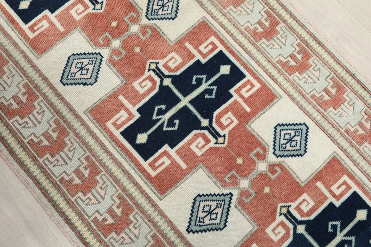 Angled close-up of the central navy and rust geometric motifs within the runner's design.