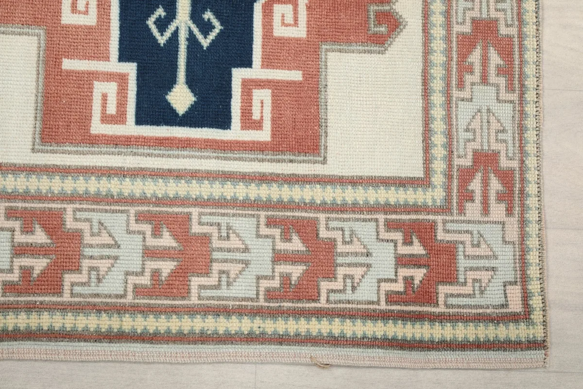 Detail shot of the runner's border design and corner, showing the rust and beige geometric patterns.